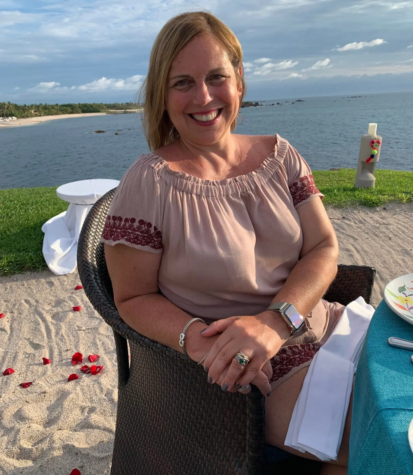 A woman sitting at the table on the beach