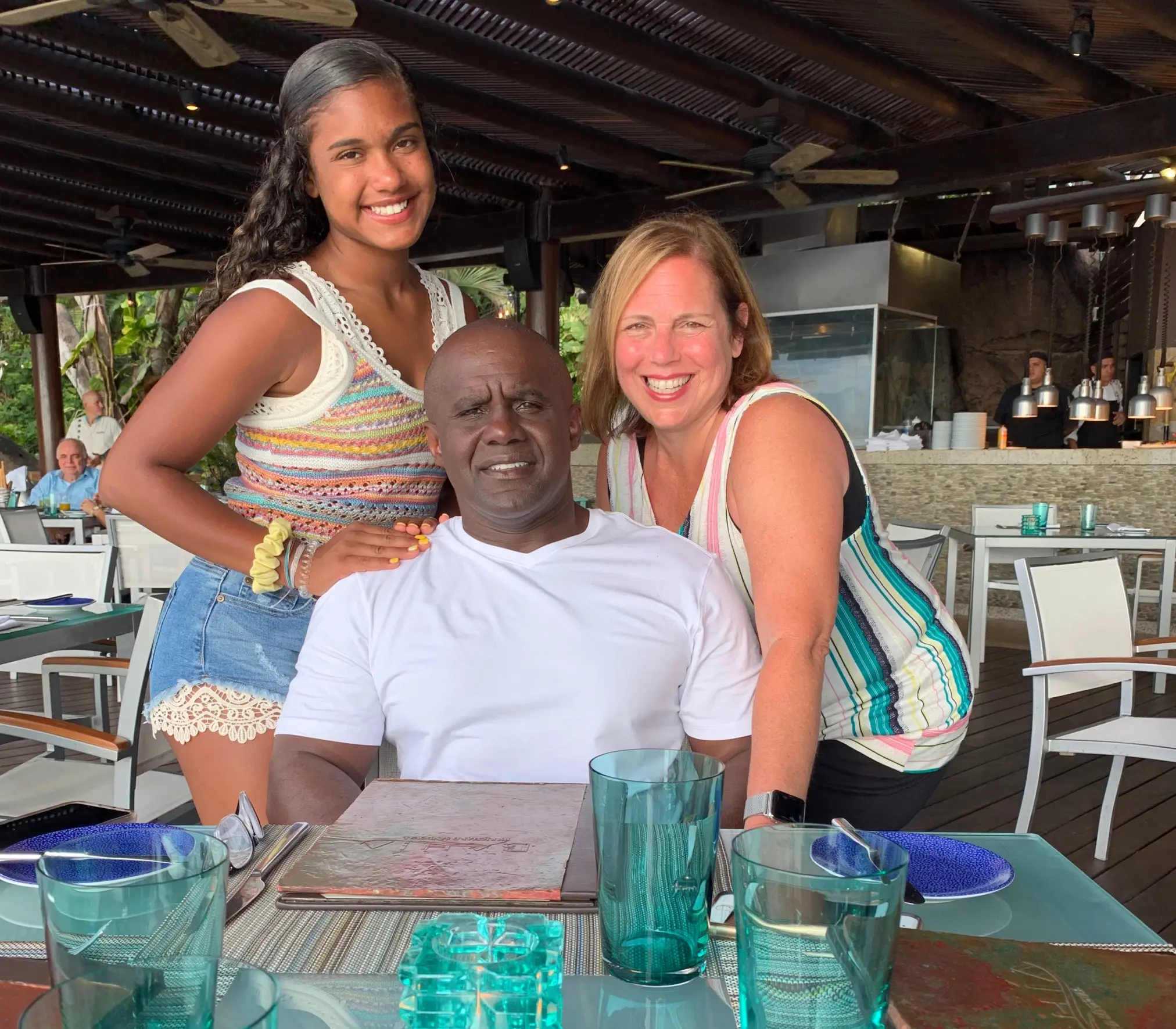 A man and two women are posing for the camera.